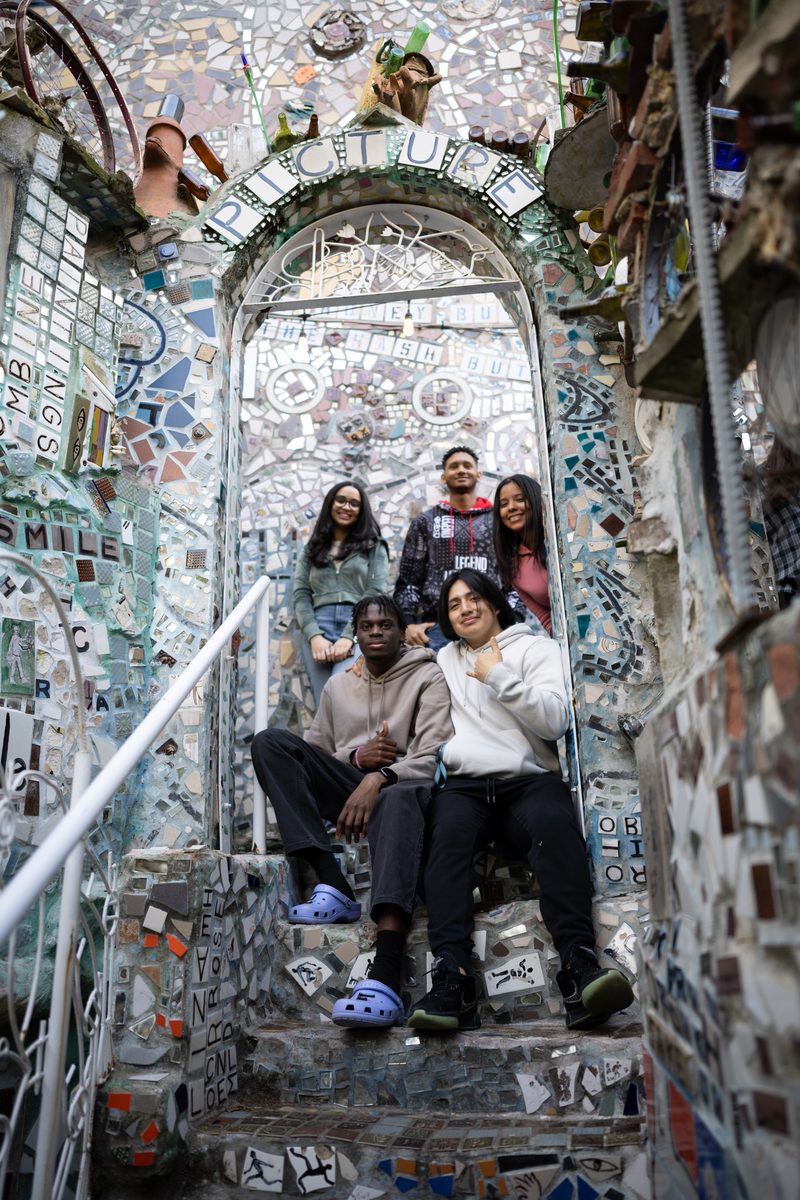Five friends pose at the mosaic staircase arch of Philadelphia's Magic Gardens on South Street.